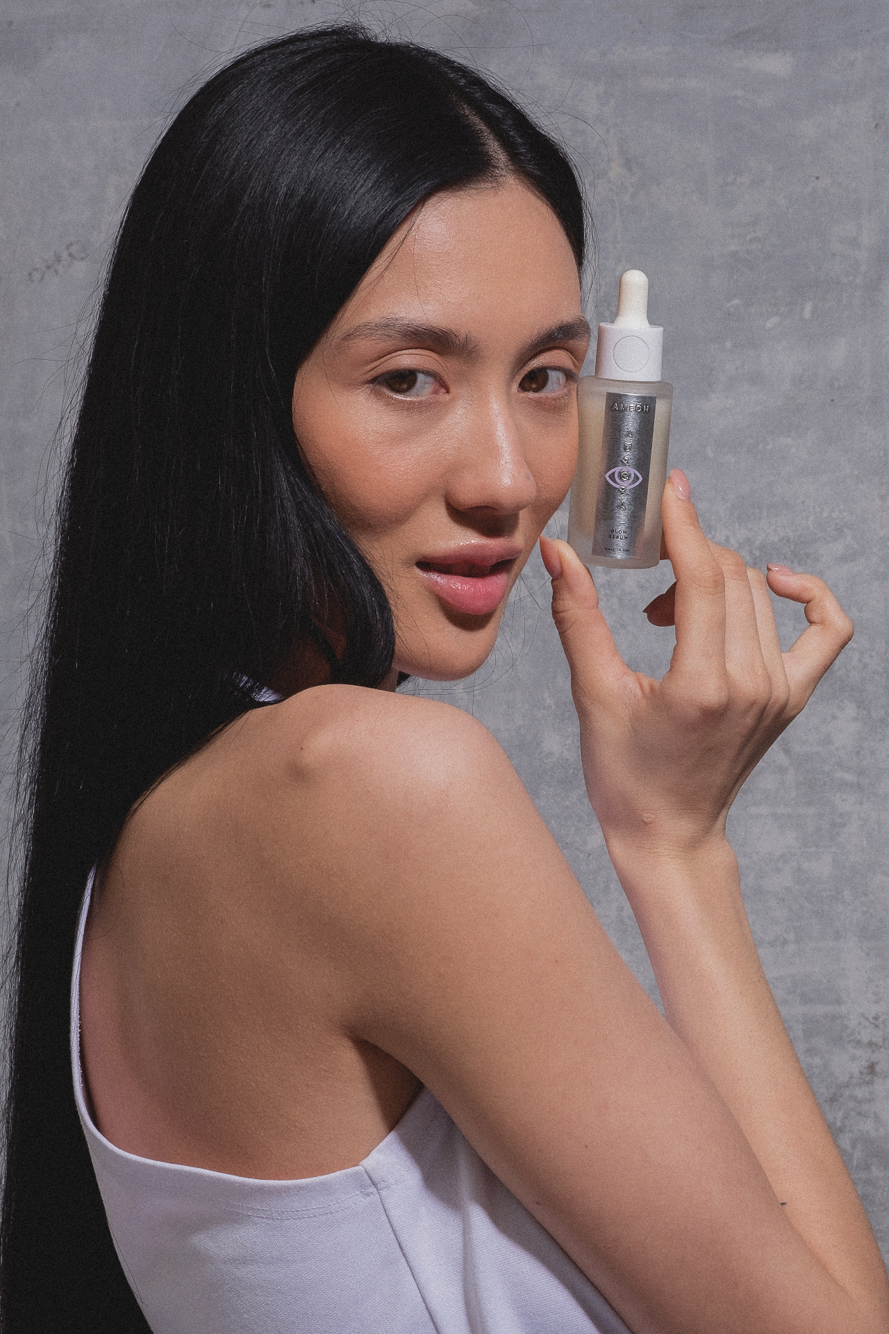Model holding Aurora Glow Serum